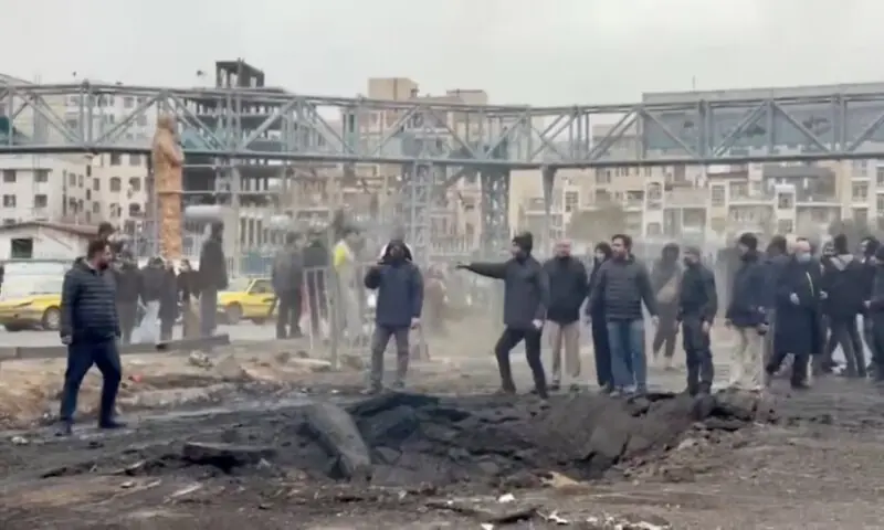 People stand at an affected area on the street following a reported strike in Tehran, Iran, in this screengrab. &ndash; Reuters