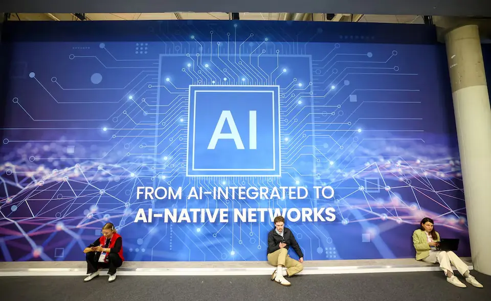 People rest sitting next to AI banner at the Mobile World Congress (MWC) at Fira de Barcelona, Spain. &ndash; Reuters