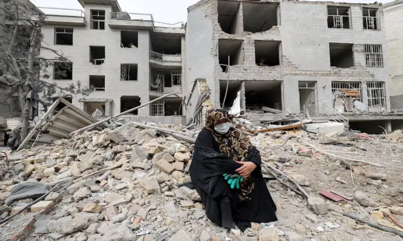 A woman sits outside her destroyed apartment after it was damaged by an airstrike while she was inside, amid the US-Israeli conflict with Iran, in Tehran, Iran. &ndash; Reuters