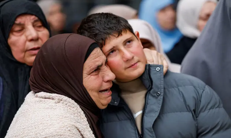 An elderly woman embraces a Palestinian child, Khaled, as mourners carry the bodies of his family, the parents and two children, who were killed in an Israeli attack, during their funeral in Tammoun town near Tubas in the Israeli-occupied West Bank, on Sunday. &ndash; Reuters
