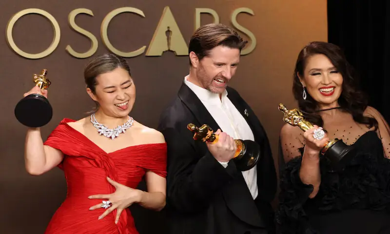 Maggie Kang, Chris Appelhans and Michelle L.M. Wong with the Oscar for Best Animated Feature Film for &ldquo;KPop Demon Hunters&rdquo;. &ndash; Reuters