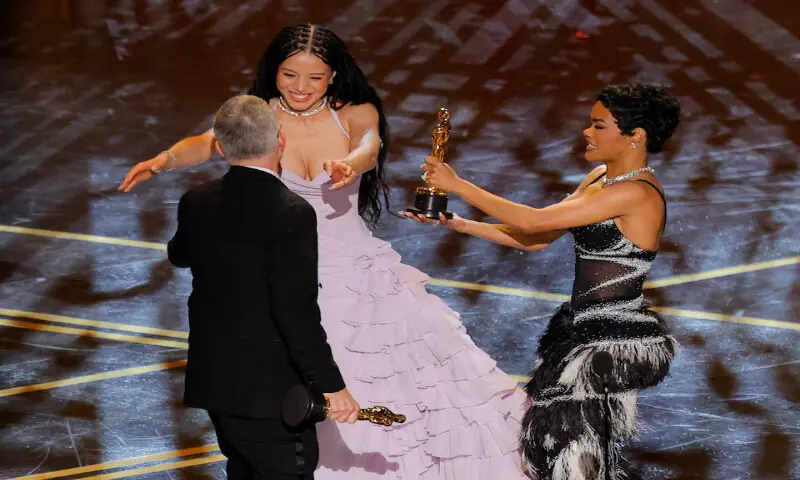 Director Paul Thomas Anderson embraces Chase Infiniti next to Teyana Taylor as they accept the Oscar for Best Picture for &ldquo;One Battle after Another&rdquo;. &ndash; Reuters