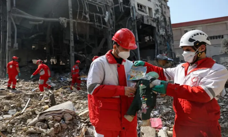 Members of a Red Crescent rescue team hold a doll, at the site of a building that was damaged by a strike, amid the U.S.-Israeli conflict with Iran, in Tehran, Iran, on March 17, 2026. Reuters