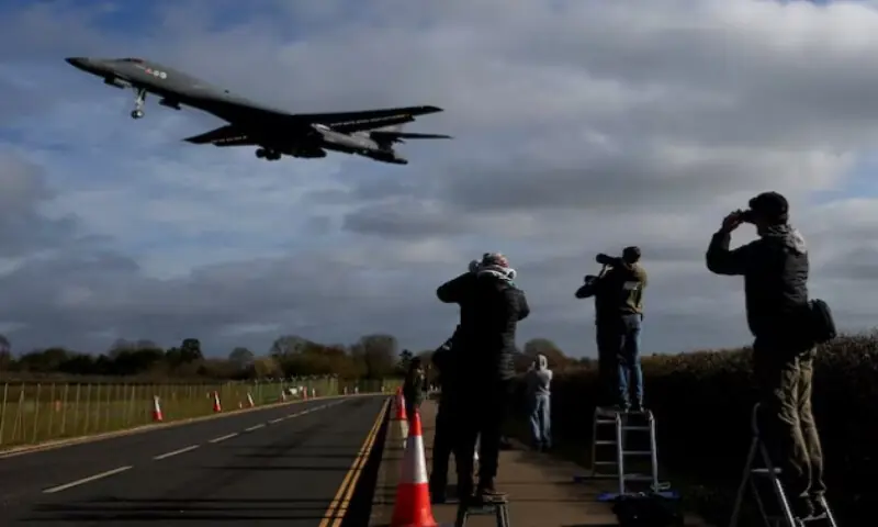 People use their cameras as a USAF B-1 bomber approaches to land at RAF Fairford airbase, used by United States Air Force personnel, amid the U.S.&ndash;Israeli conflict with Iran, in Fairford, Gloucestershire, Britain, on March 17, 2026. Reuters file