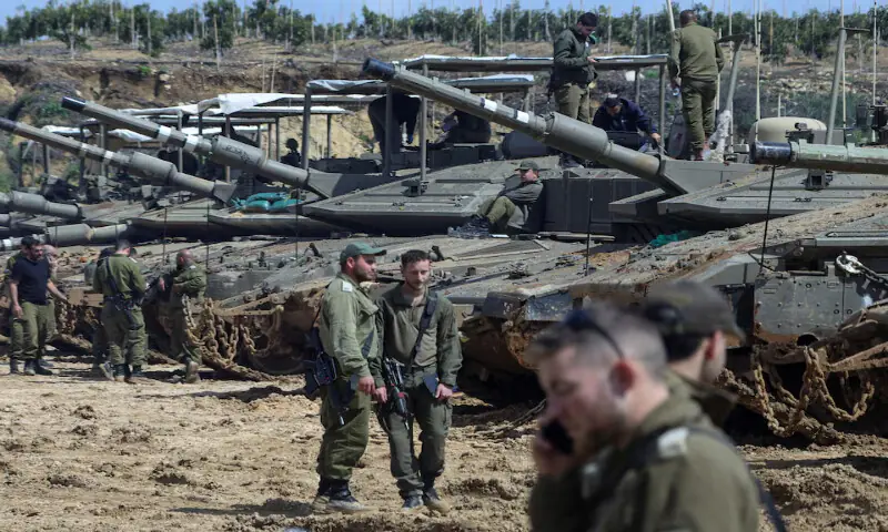 Israeli soldiers stand next to tanks near the Israeli side of the border with Lebanon in northern Israel on Monday. &ndash; Reuters