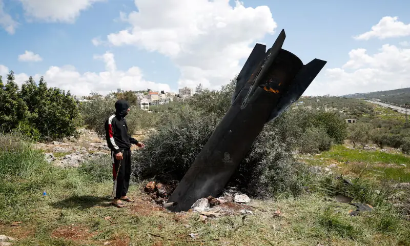 A person stands next to remnants of a missile stuck in the ground found in Kifl Haris village, near Nablus in the Israeli-occupied West Bank, on Tuesday. &ndash; Reuters