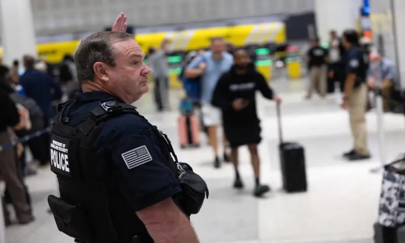 A Department of Homeland Security officer directs passengers as they wait in long TSA lines amid a funding standoff that has forced 50,000 airport security officers to go without pay, causing delays at airports, at the George Bush Intercontinental Airport in Houston, Texas, US. &ndash; Reuters