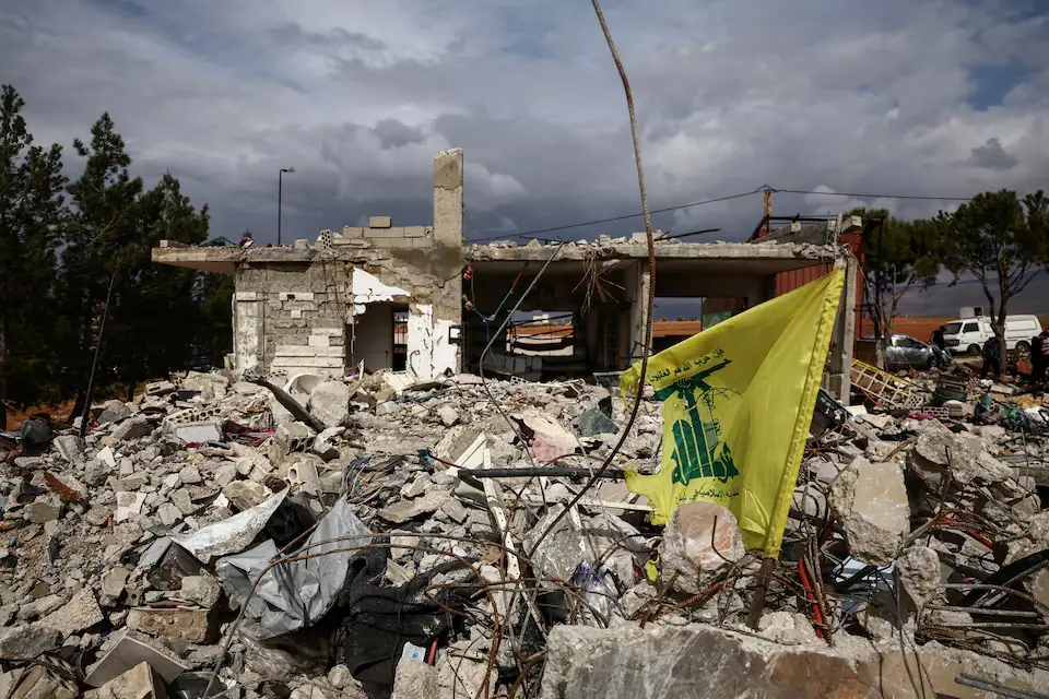 Hezbollah flag in front of a house destroyed by an Israeli strike, following an escalation between Hezbollah and Israel, amid the U.S.-Israeli conflict with Iran. &ndash; Reuters