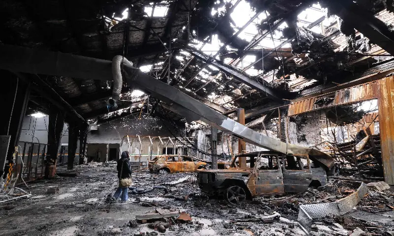 A journalist stands next to the wreckage of a vehicle at car service centre in eastern Tehran that was hit by a missile strike, on March 28, 2026. AFP A journalist stands next to the wreckage of a vehicle at car service centre in eastern Tehran that was hit by a missile strike, on March 28, 2026. AFP