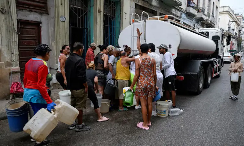People gather around a water tanker truck to fill up buckets and other containers as severe fuel shortages have disrupted water pumping and distribution in Havana, Cuba. &ndash; Reuters