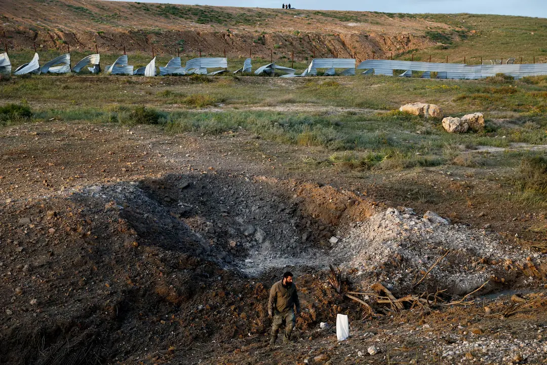 A man stands at an impact site following an Iranian missile strike, as the U.S.-Israeli conflict with Iran continues, in southern Israel. &ndash; Reuters