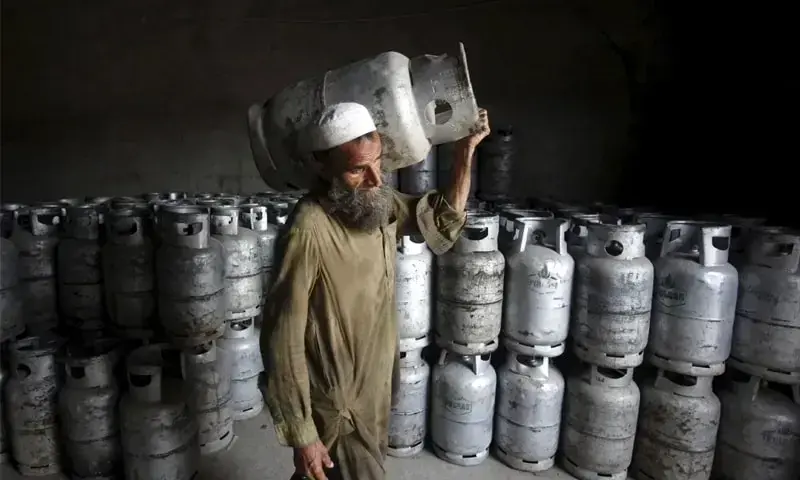 In this file photo, a man carries an LPG cylinder at a gas distribution centre in Peshawar. Reuters
