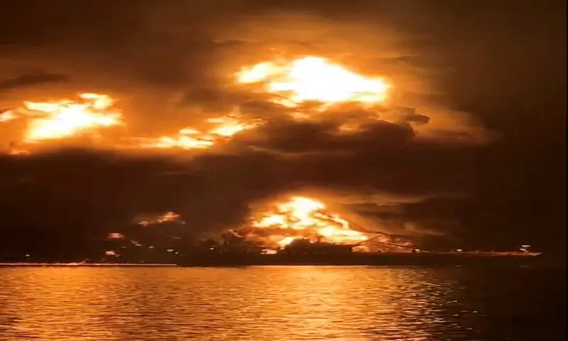 A ship illuminated by fire from a burning vessel, after Iranian explosive-laden boats attacked two fuel tankers in Iraqi waters setting them ablaze. &ndash; Reuters