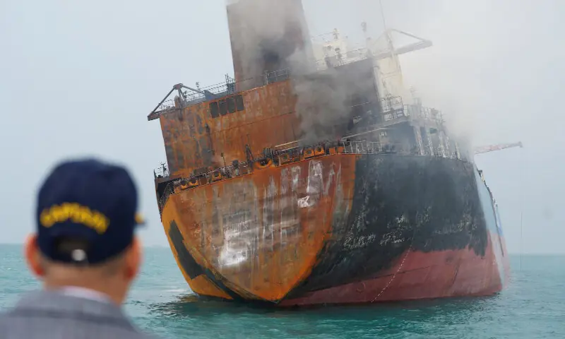 A man looks out at a tanker carrying Iraqi fuel oil after catching fire following an attack in Iraqi territorial waters off Basra, Iraq. &ndash; Reuters