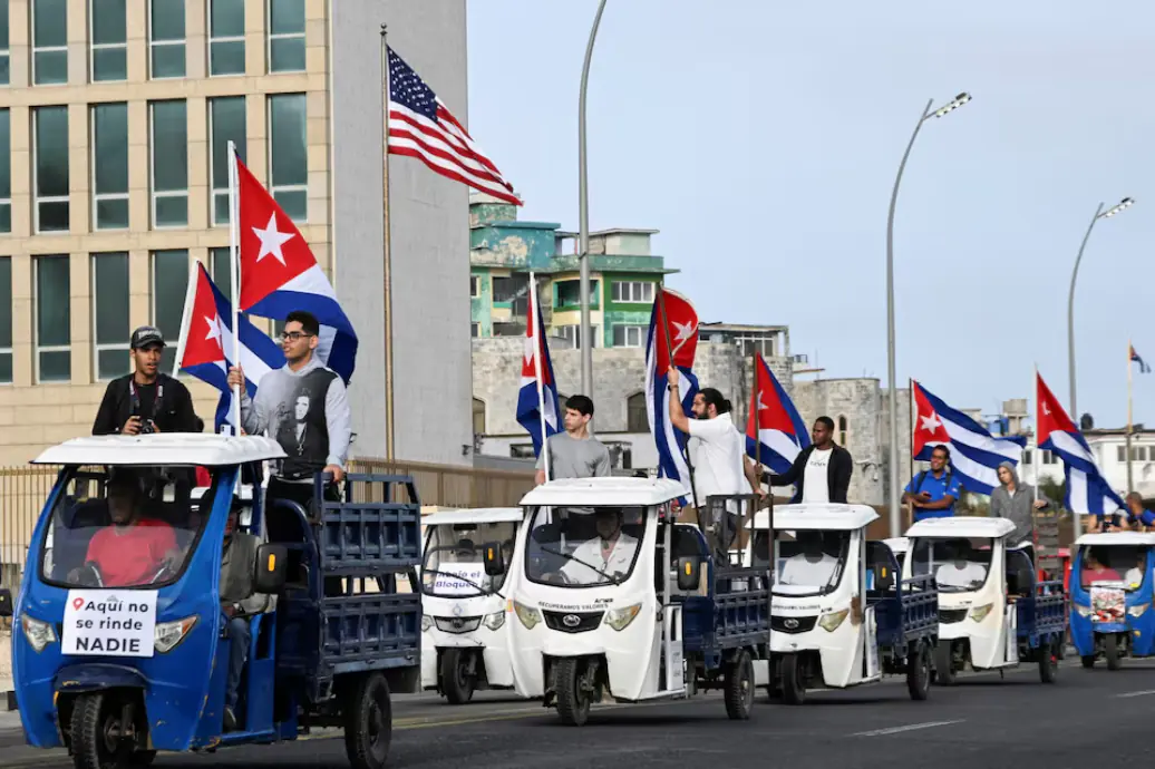 A person riding in an electric vehicle carries a sign with an image of late Cuban President Fidel Castro that reads, “The Cuban people shall win” during an anti-imperialist march amid a months-long energy crisis since US President Donald Trump’s administration cut off its fuel supply, Havana, Cuba. – Reuters A person riding in an electric vehicle carries a sign with an image of late Cuban President Fidel Castro that reads, “The Cuban people shall win” during an anti-imperialist march amid a months-long energy crisis since US President Donald Trump’s administration cut off its fuel supply, Havana, Cuba. – Reuters