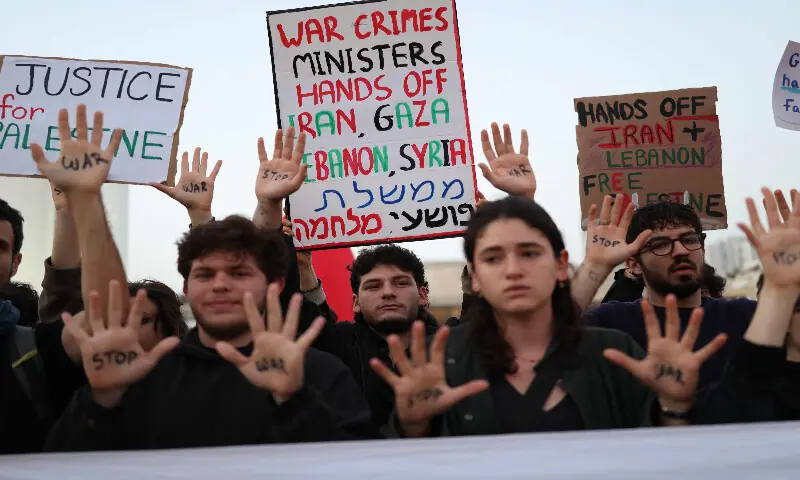 Israeli left-wing activists hold placards while taking part in a protest at HaBima Square in Tel Aviv on April 4, 2026, against the ongoing war with Iran. AFP