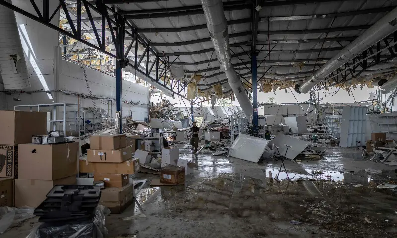 A man assesses the damage at a factory that got hit by a missile in Petah Tikva, east of Tel Aviv, on April 3, 2026. AFP