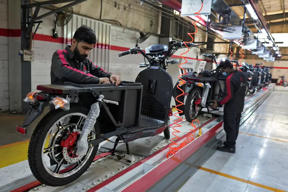 Workers assemble parts of electric motocycles on the production line at the ZYP Technology&rsquo;s facility in Lahore, Pakistan. &ndash; Reuters
