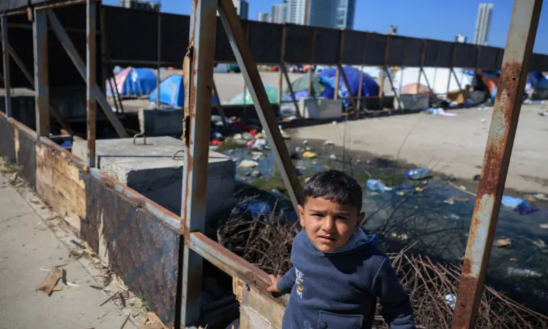 A child looks on at the makeshift encampment, by people who fled their homes after Israeli evacuation orders, in Beirut, Lebanon