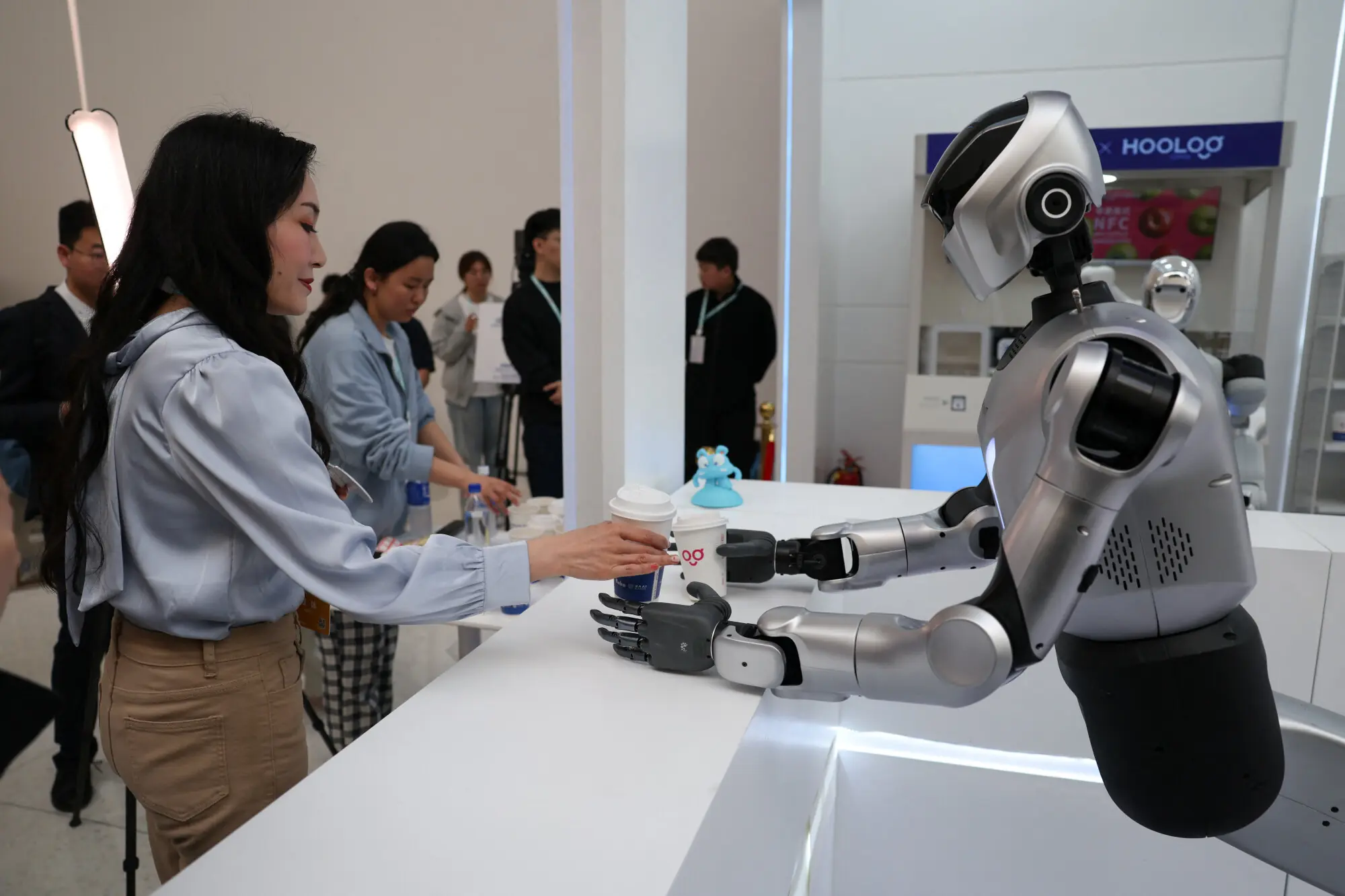 A Kuavo-5W humanoid robot by Leju Robotics passes freshly made coffee to a journalist during a demonstration simulating a cafe, at the 2026 Zhongguancun forum, in Beijing, China. &ndash; Reuters