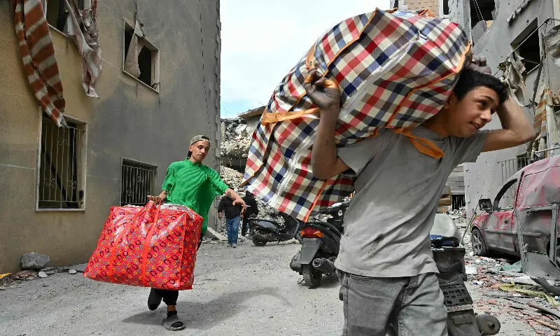 This photograph, taken on April 10, 2026, during a media tour organised by Hezbollah&rsquo;s media office, shows residents carrying salvaged belongings at southern Beirut&rsquo;s Chweifat-Amrousiyeh neighbourhood that was targeted in an Israeli strike earlier this week. AFP