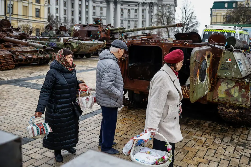 People with Easter baskets walk by destroyed Russian military equipment during a 32‑hour ceasefire declared by Russia, in Kyiv, Ukraine. &ndash; Reuters