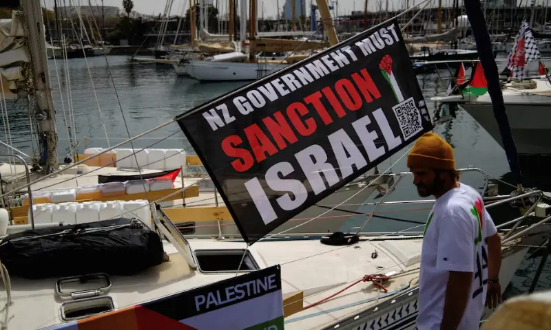 A banner with a message calling for the New Zealand government to sanction Israel hangs on a boat of a humanitarian flotilla preparing to depart for Gaza, in Barcelona, Spain. &ndash; Reuters