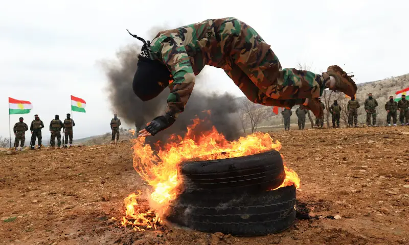 A female fighter from the Kurdistan Freedom Party, known as PAK, leaps over burning tyres during training at a base that was later bombed by Iran. &ndash; Reuters