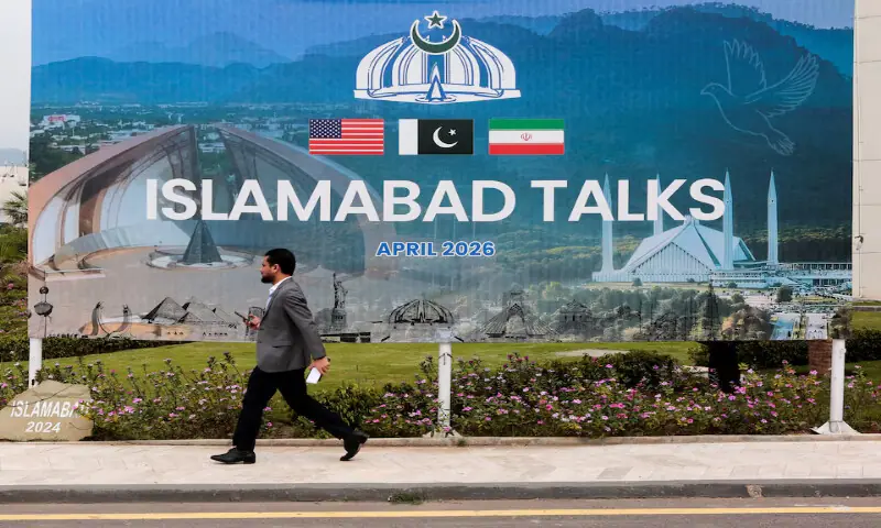 A man walks past a billboard near the media centre set up for the US-Iran talks in Islamabad. &ndash; Reuters