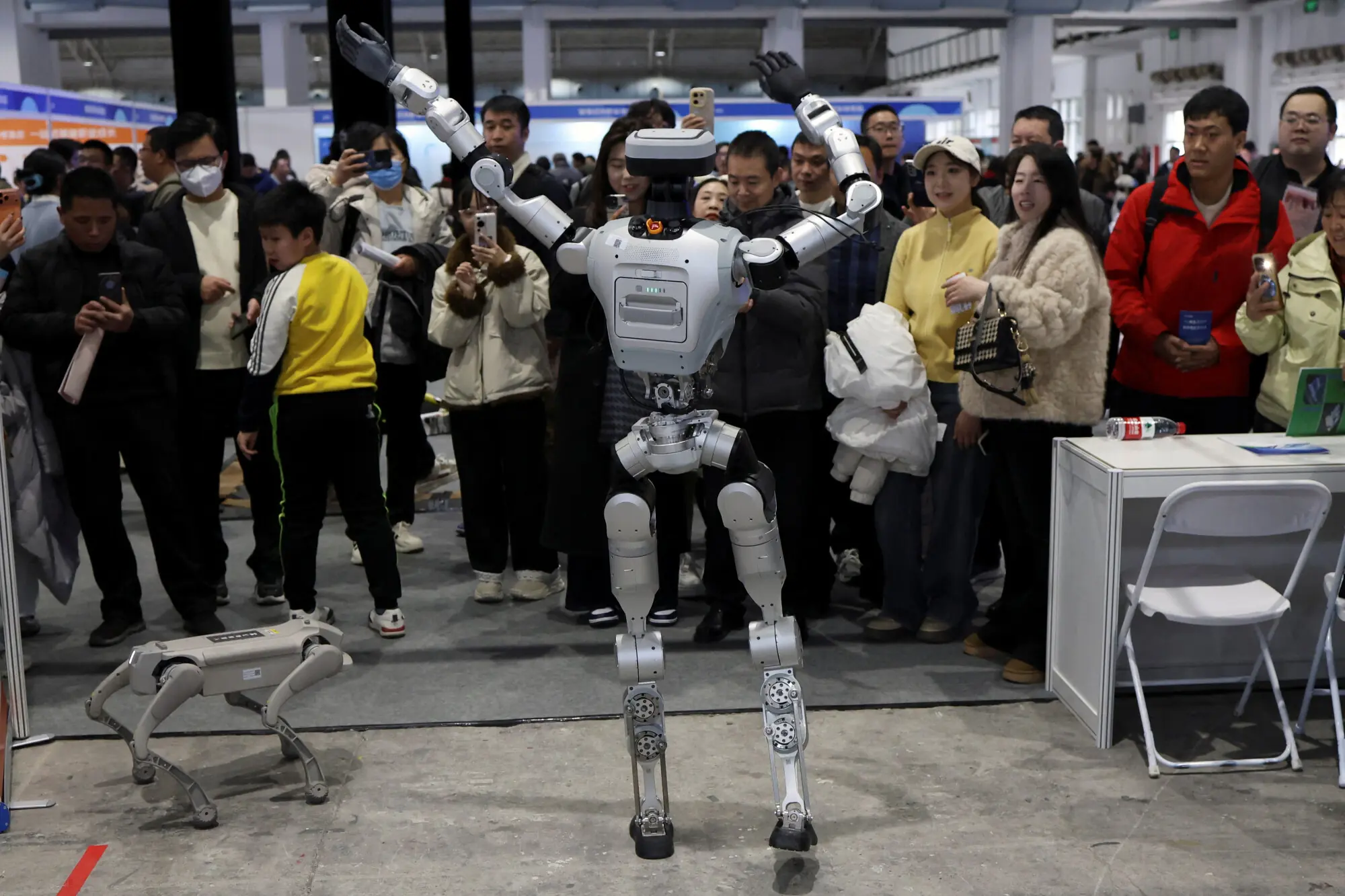 A humanoid robot dances in front of visitors at a job fair in Beijing, China. &ndash; Reuters