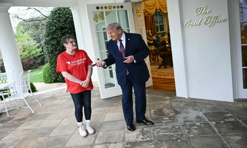 US President Donald Trump tips Doordash delivery worker Sharon Simmons after she delivered Mcdonald&rsquo;s outside of the Oval Office at the White House, in Washington, DC, on April 13, 2026. AFP
