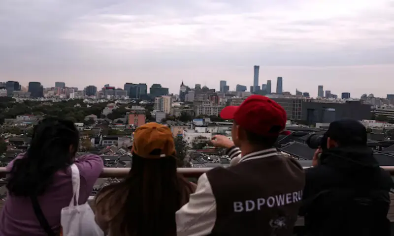 People look at the city skyline at a rooftop of a building in Beijing, China. &ndash; Reuters file