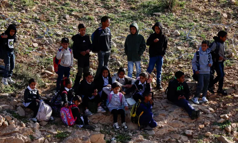 Palestinian school children gather by a barbed wire fence installed by Israeli settlers, which blocked their access to the school in Umm al-Khair village in Masafer Yatta, in the Israeli-occupied West Bank. &ndash; Reuters