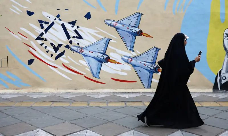A woman walks next to an anti-Israeli mural on a street, amid a ceasefire between US and Iran, in Tehran, Iran, on April 20, 2026. Reuters