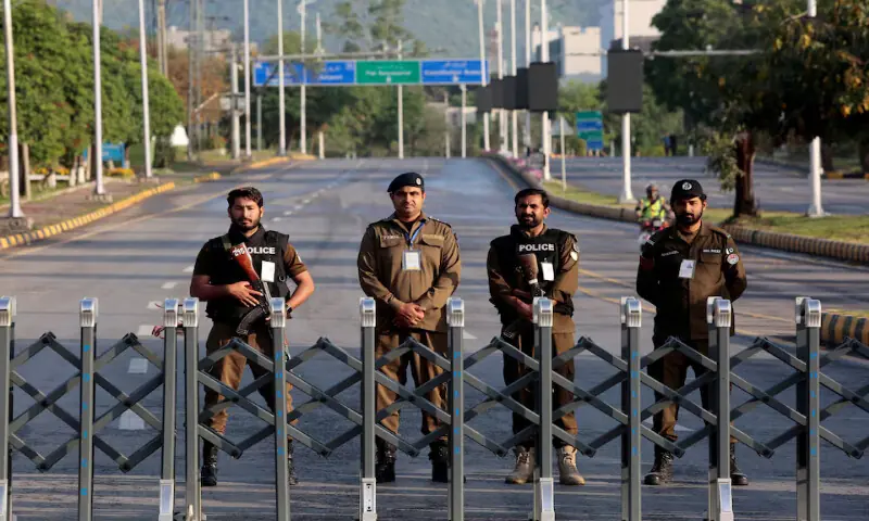 Police officers stand guard behind a barricade near Serena Hotel in Islamabad. -- Reuters
