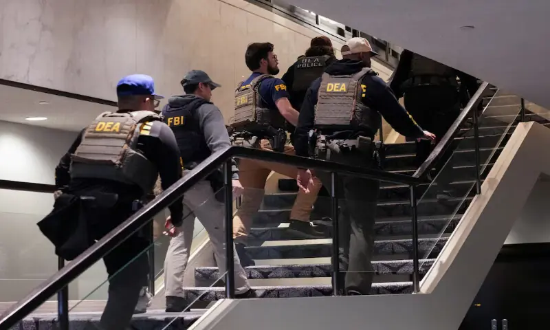 FBI and DEA personnel walk at the venue in Washington, DC. -- Reuters