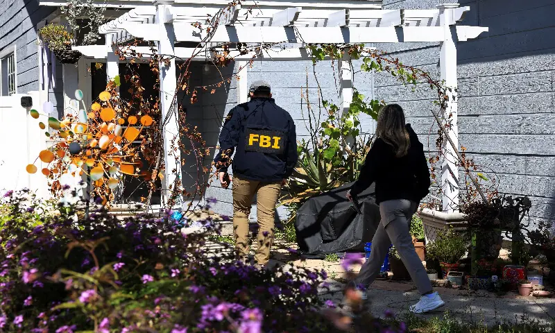An FBI member walks up to a building next to the house associated with Cole Tomas Allen, the suspect in the shooting incident in Washington at the annual White House Correspondents' Association dinner, in Torrance, California. -- Reuters