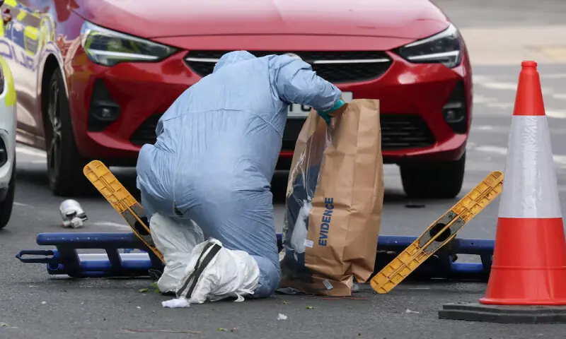 A member of the forensic team uses an evidence bag as they work at the scene after a man was arrested following a stabbing incident in the Golders Green area in London, Britain. -- Reuters