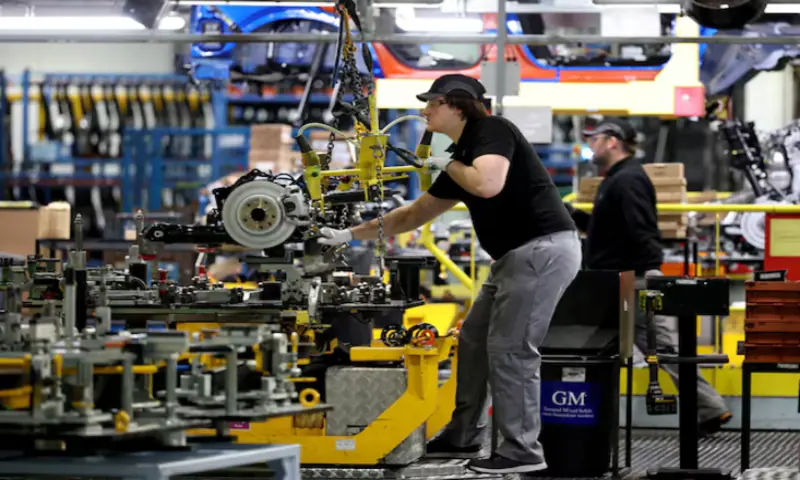 A worker uses a hoist to move components along the production line for the Qashqai model car at the Nissan car factory in Sunderland. -- Reuters