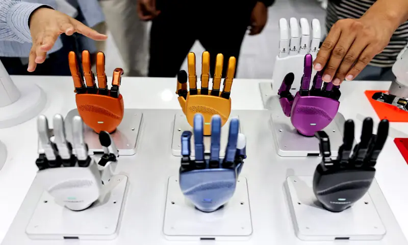 Robotic hands are displayed on a table as visitors reach toward them at the office of Linkerbot, in Beijing, China. -- Reuters