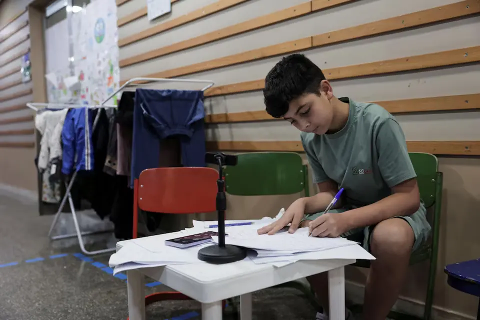 Mohamad Khalil, 11, displaced from southern Lebanon, attends an online class in Hariri High School II, used as a temporary shelter for displaced people, in Beirut, Lebanon. -- Reuters