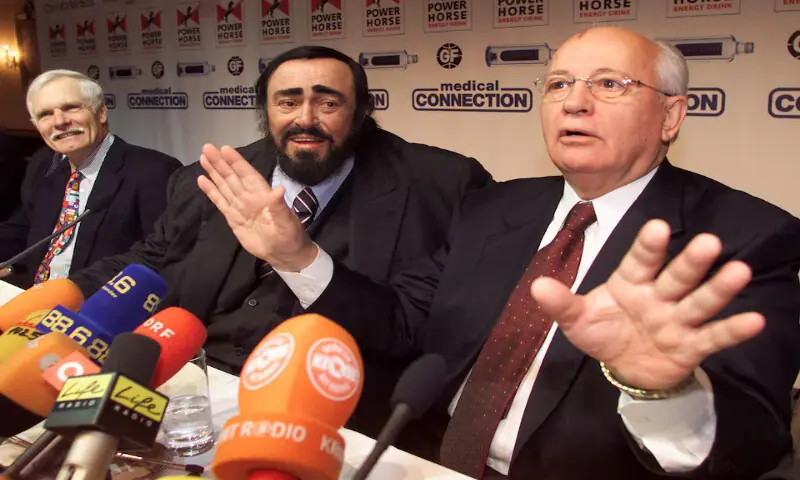 Ted Turner and singer Luciano Pavarotti listen to former Soviet president Mikhail Gorbachev talking to journalists in Vienna. -- Reuters file