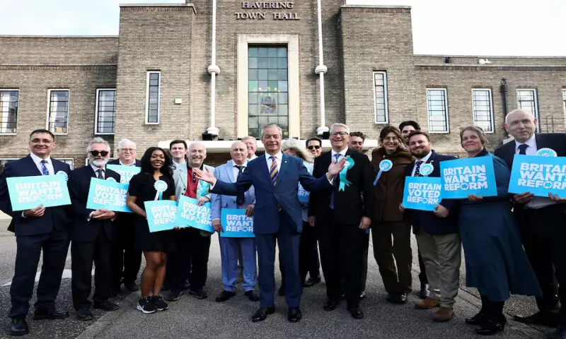 Britain's Reform UK leader Nigel Farage poses with newly elected councillors at the Havering Town Hall in the London Borough of Havering, Britain. -- Reuters