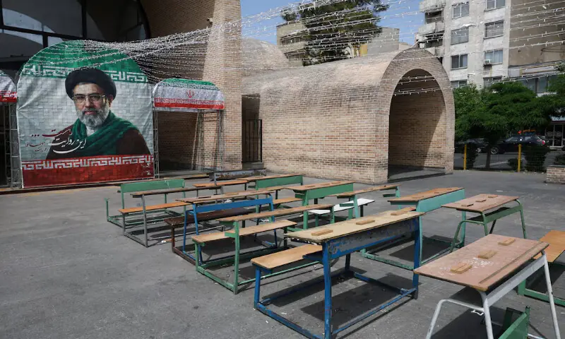 A banner with a picture of new Supreme Leader Mojtaba Khamenei next to a symbolic classroom of the Minab school students who were killed in a US strike, in Tehran, Iran. -- Reuters