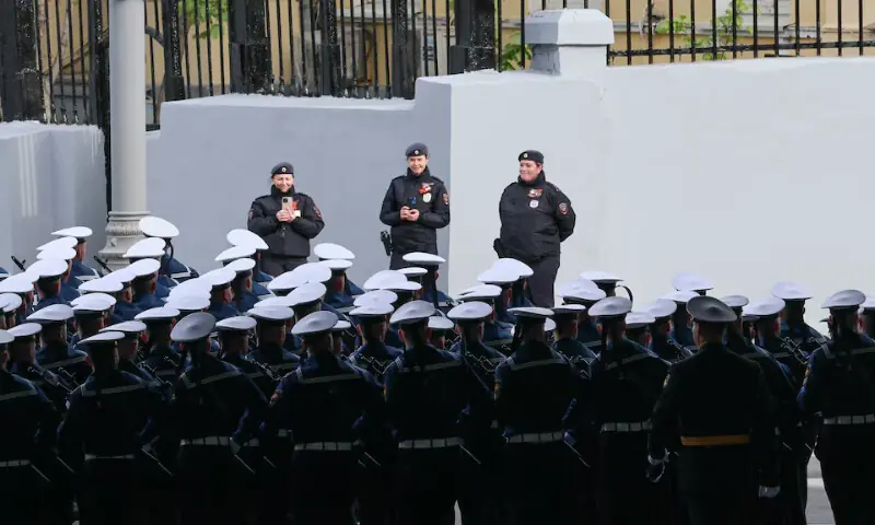 Police officers take pictures of Russian service members lining up before a military parade on Victory Day in central Moscow, Russia, on Saturday. -- Reuters