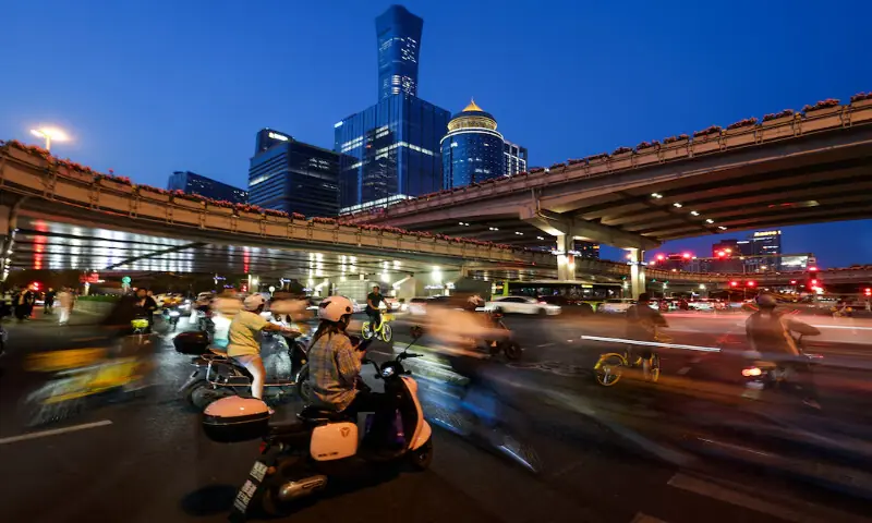 People ride scooters and bicycles at a junction, with skyscrapers of Beijing Central Business District seen in the background, ahead of this week’s US President Donald Trump visit to China, in Beijing, China, on May 11, 2026. Reuters People ride scooters and bicycles at a junction, with skyscrapers of Beijing Central Business District seen in the background, ahead of this week’s US President Donald Trump visit to China, in Beijing, China, on May 11, 2026. Reuters