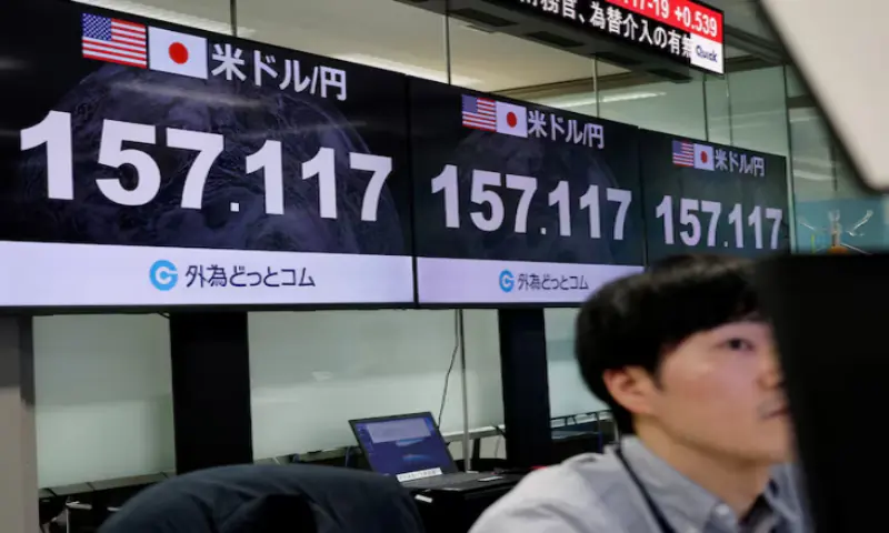 An employee of the foreign exchange trading company Gaitame.com works in front of monitors displaying the current Japanese yen exchange rate against the US dollar, at their dealing room in Tokyo, Japan. -- Reuters