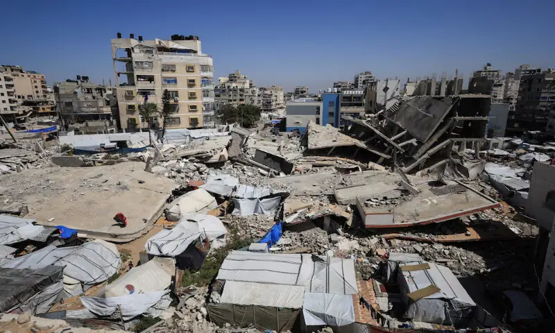 Tents sheltering displaced Palestinians amidst the rubble of residential buildings destroyed during the two-year Israeli offensive in Gaza City. -- Reuters
