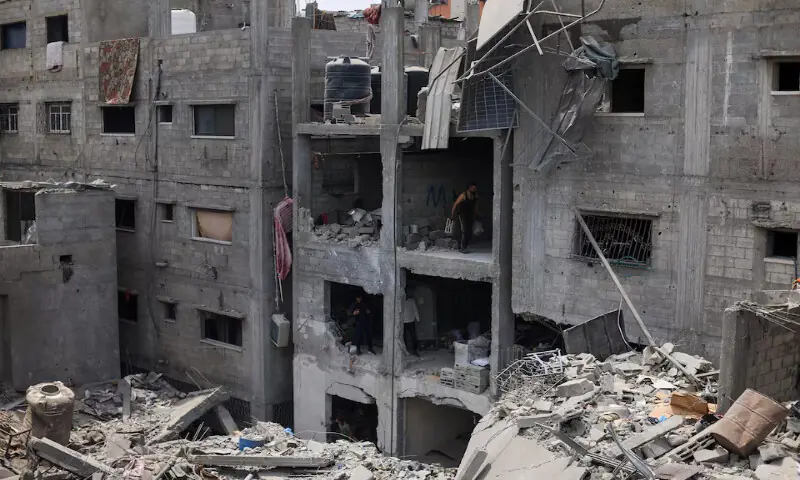 Palestinians inspect the site of an Israeli air strike on houses at Shati refugee camp in Gaza City. -- Reuters