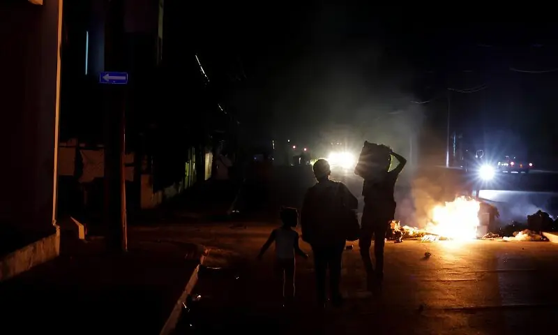 People walk past trash set on fire in the middle of a street during a protest against frequent power cuts in Havana, Cuba. -- Reuters People walk past trash set on fire in the middle of a street during a protest against frequent power cuts in Havana, Cuba. -- Reuters